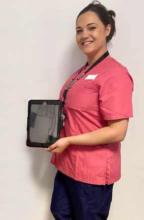 A member of staff at UHMBT holding up one of the new iPads.png