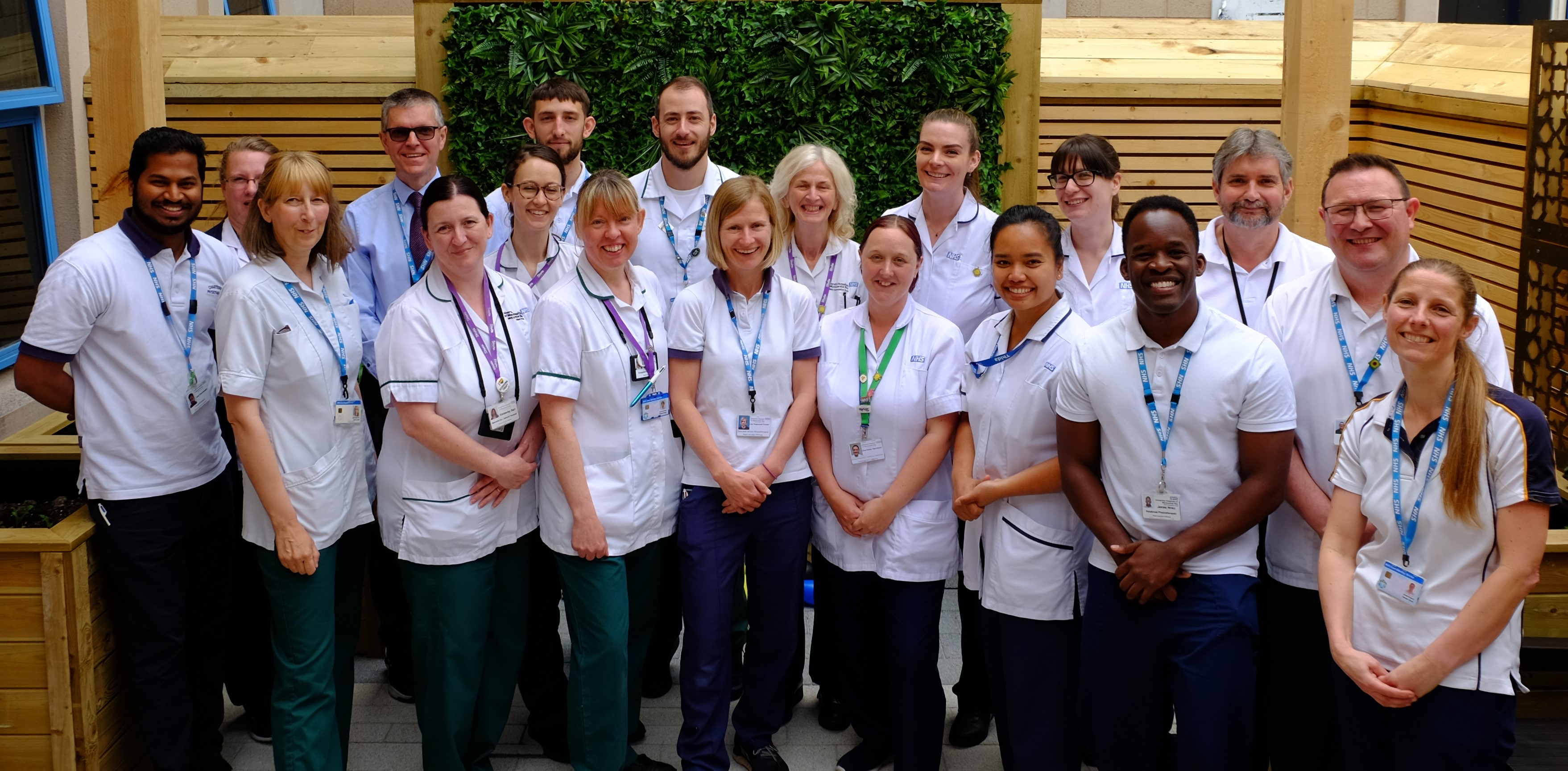 Group photo of stroke service colleagues standing outside and smiling to camera
