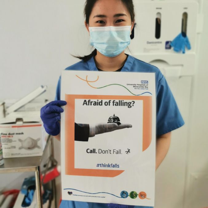 Falls Awareness Week colleague with poster 1.jpeg